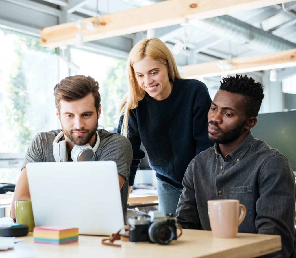 happy colleagues sitting in office coworking e1617897505461
